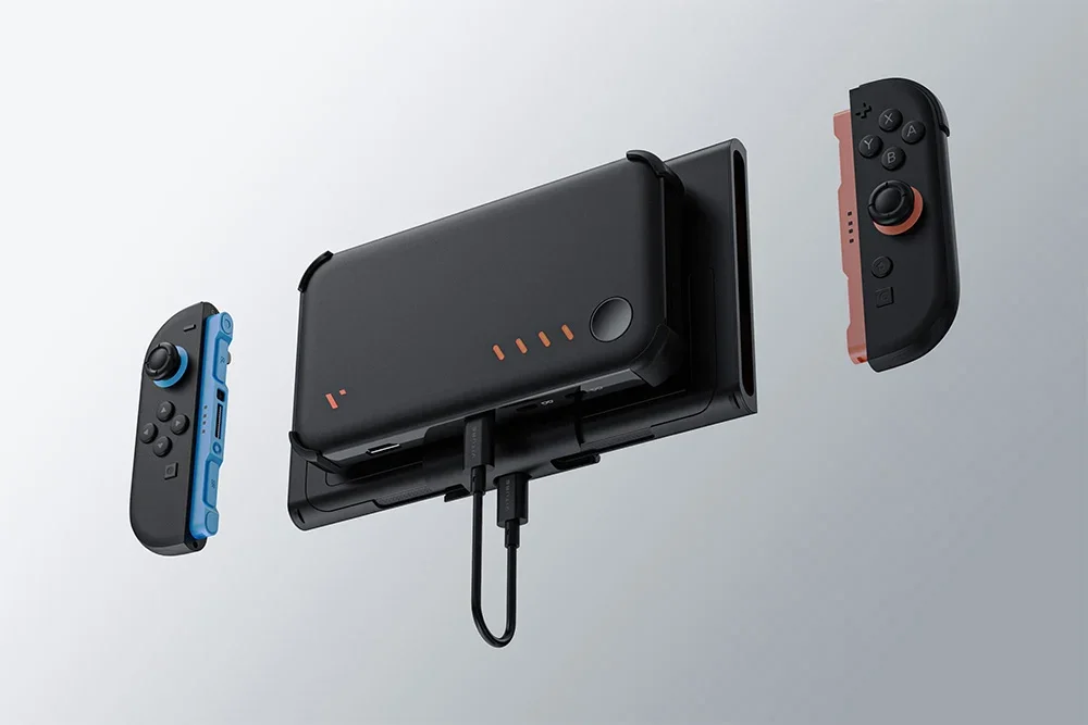 Black holder with attached powerbank and two detached controllers floats above a bright background