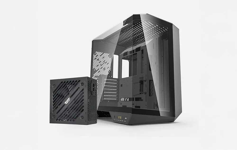 Melns barošanas bloks stāv blakus pelēkam datora korpusam gaišā fonā