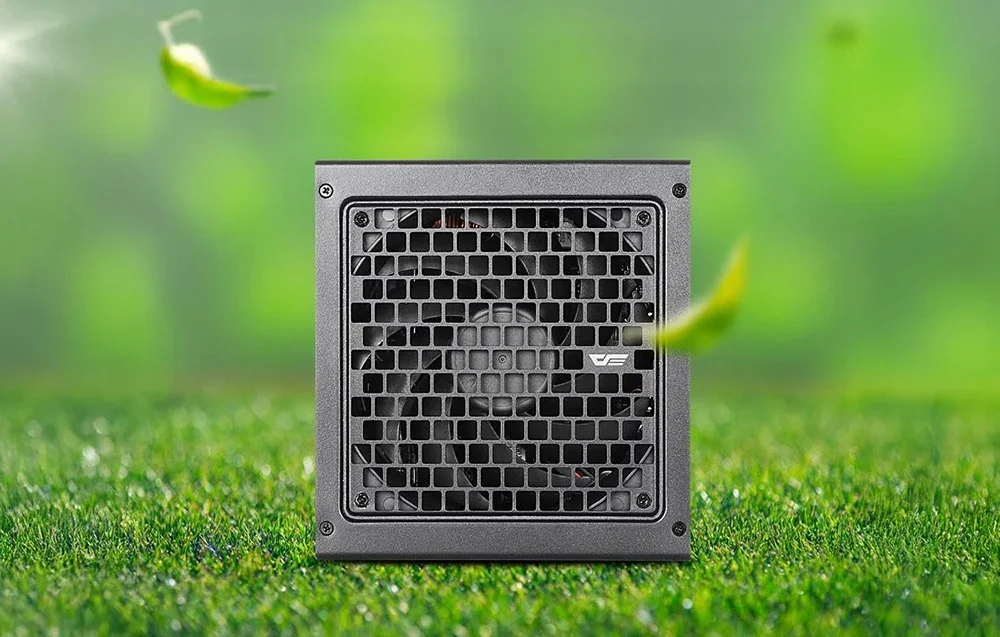 Melns datora barošanas bloks ar ventilācijas sietu uz mākslīgā zāliena