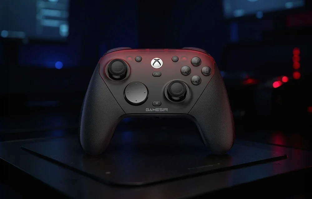 Melns un sarkans GameSir kontrollera komplekts uz paliktņa tumšā telpā ar fona apgaismojumu.