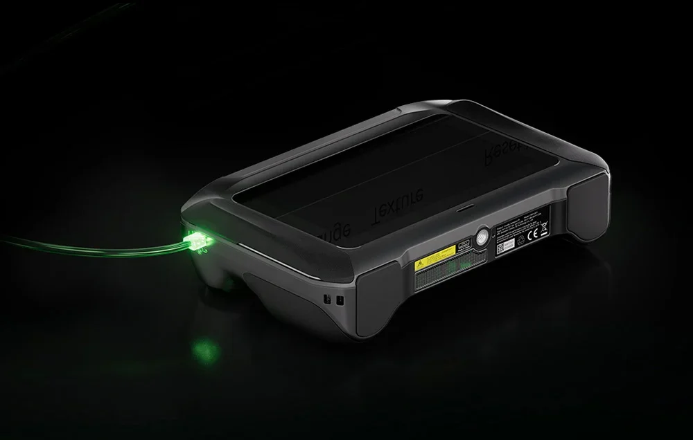 Creality 3D scanner tiek lādēts ar zaļi izgaismotu kabeli
